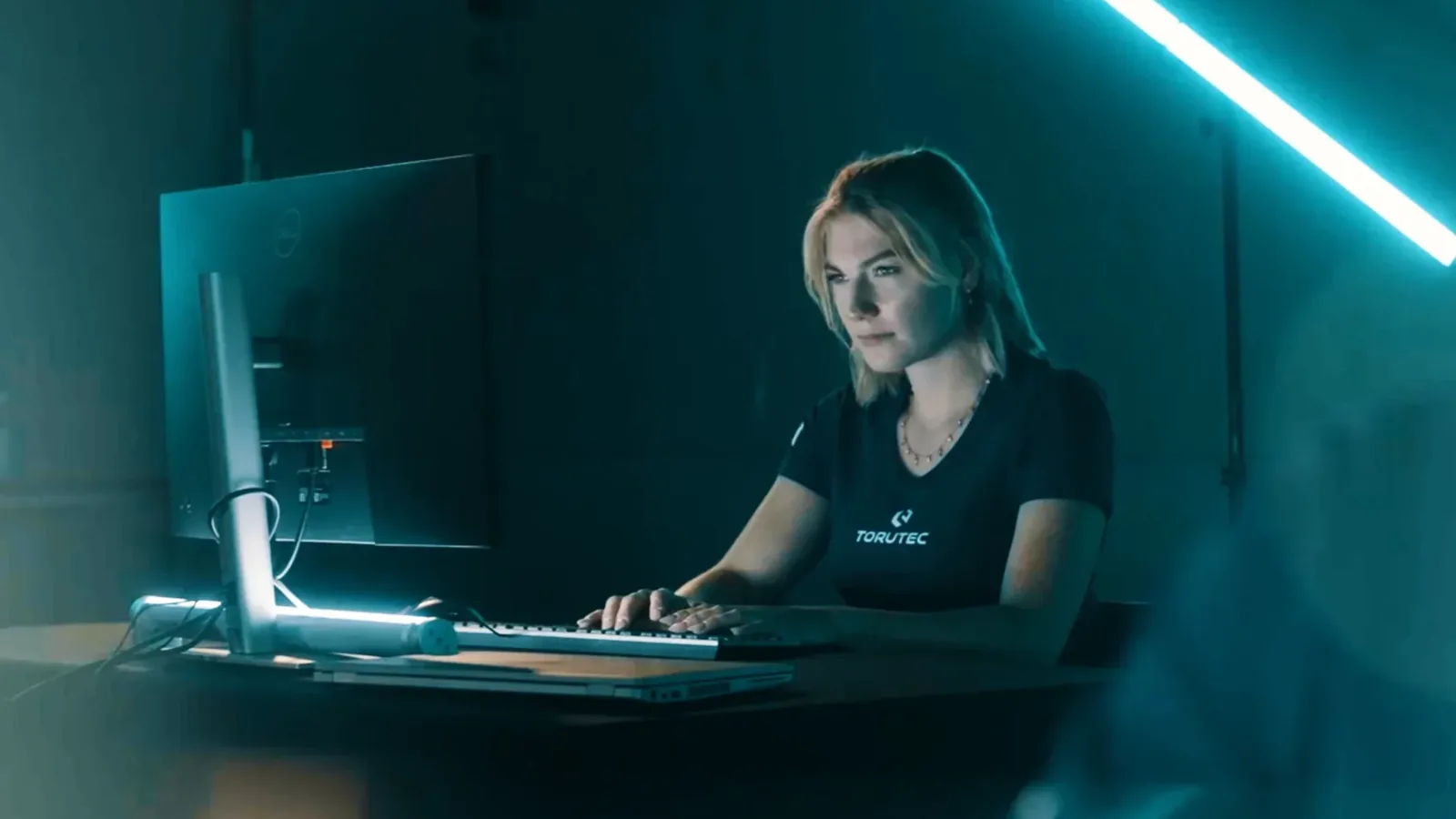 Mitarbeiterin überwacht abends die IT-Systeme an ihrem Arbeitsplatz